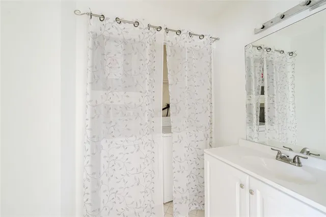a bathroom with a sink a mirror a shower and vanity