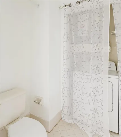 a white toilet sitting next to a shower curtain