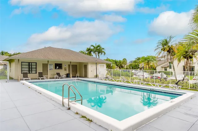 a view of a patio with swimming pool and sitting area
