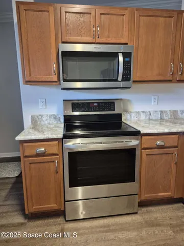 a kitchen with stainless steel appliances granite countertop a stove microwave and sink