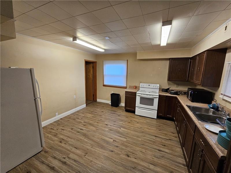 325 Adams Street Rochester, PA 15074 - Photo 5 of 14 a kitchen with stainless steel appliances a stove a refrigerator a sink a stove a microwave and wooden floors