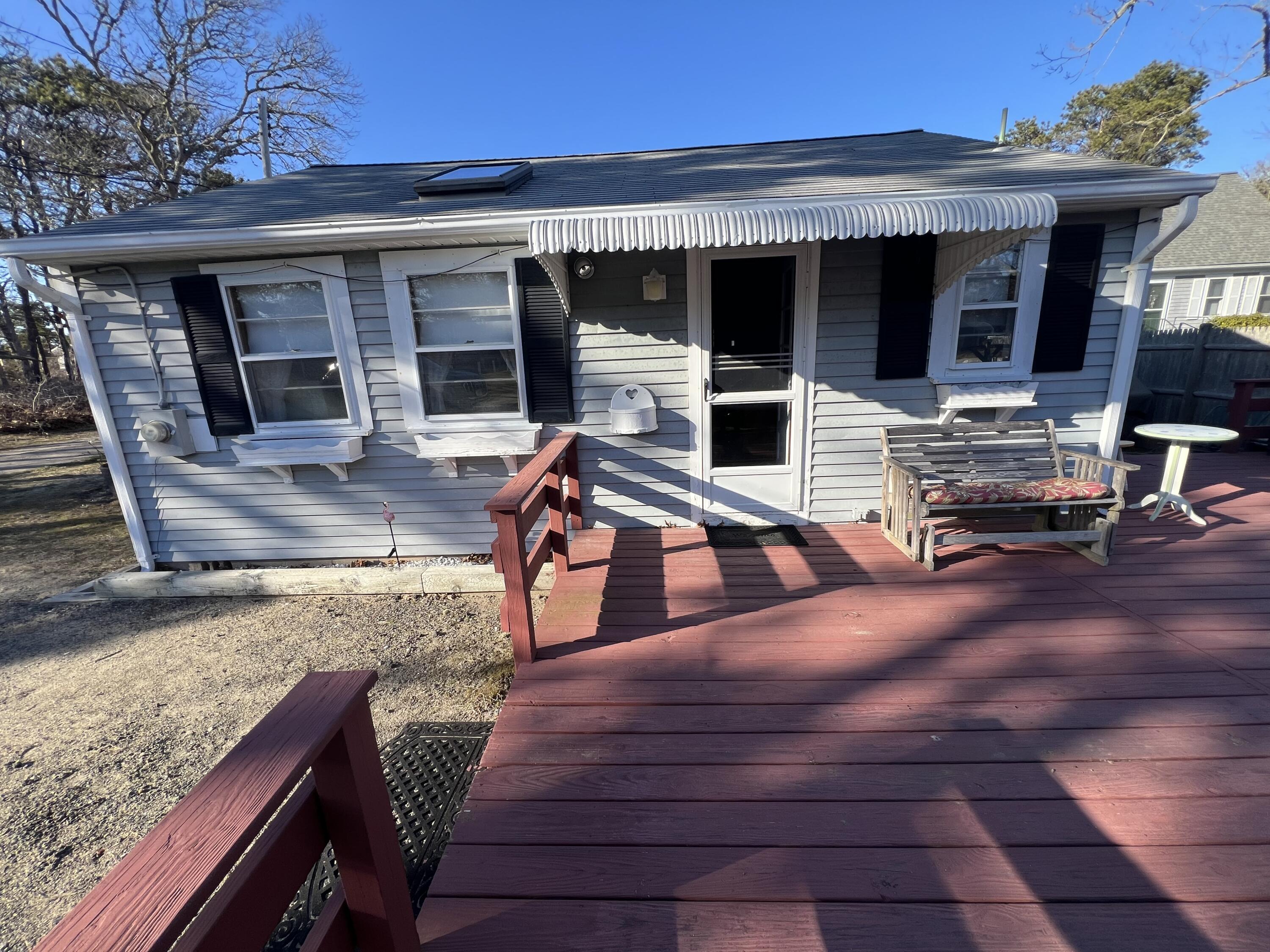 7 A Toms Path Dennis Port, MA 02639 - Photo 3 of 23 a view of a patio with table and chairs with wooden floor and fence