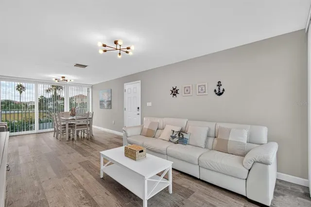 a living room with furniture large window and wooden floor