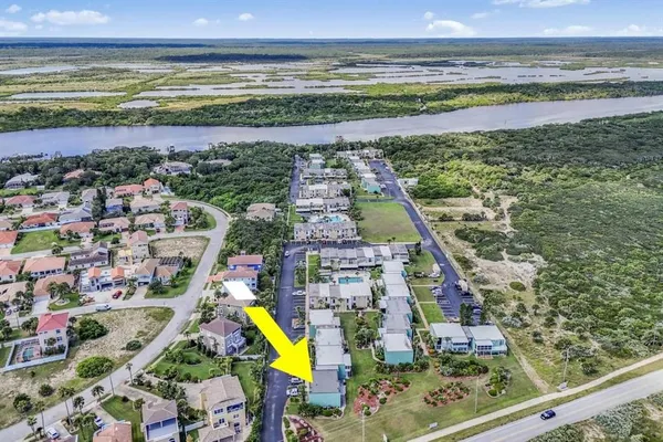 an aerial view of multiple houses with yard