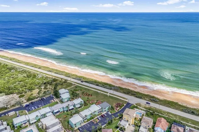 an aerial view of a house with swimming pool and outdoor seating