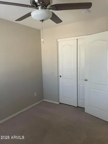an empty room with a window and a fan