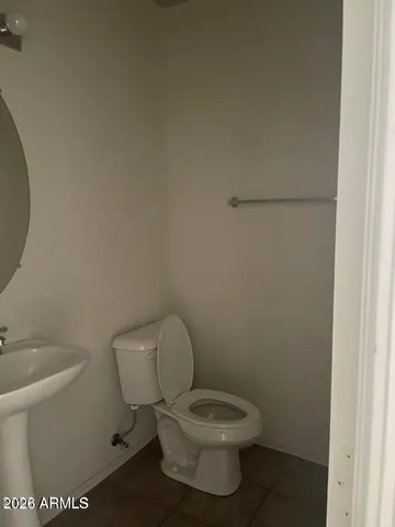 a white toilet sitting next to a white sink and vanity