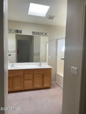 a bathroom with a tub sink and mirror