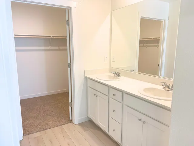 a spacious bathroom with a double vanity sink and a mirror