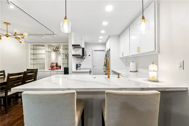 a kitchen with a sink a refrigerator and cabinets