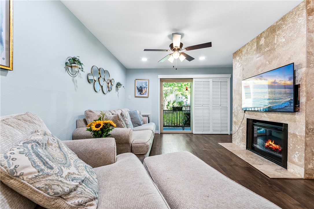 7890 East Spring Street, Unit 22F Long Beach, CA 90815 - Photo 24 of 60 a living room with furniture a flat screen tv and a fireplace