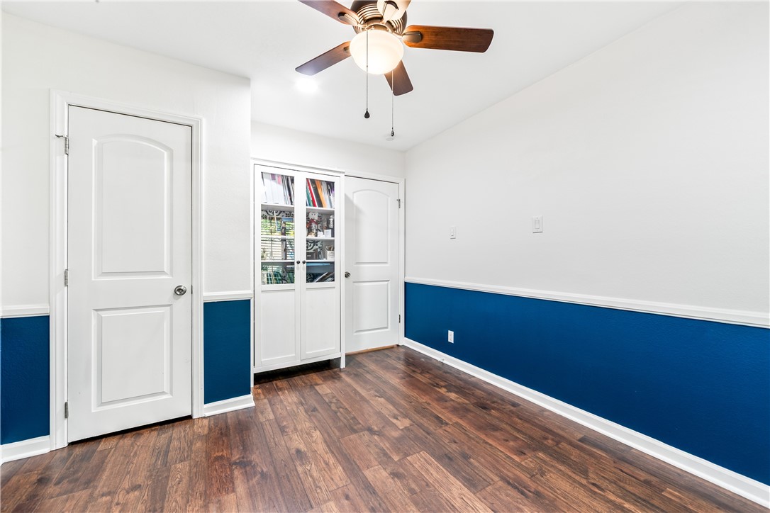 7890 East Spring Street, Unit 22F Long Beach, CA 90815 - Photo 42 of 60 an empty room with wooden floor chandelier fan and windows