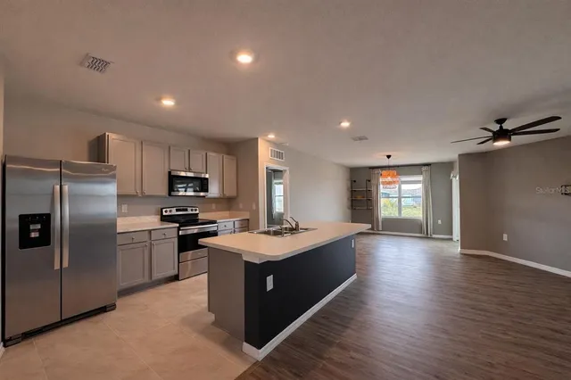 a kitchen with stainless steel appliances granite countertop a sink refrigerator and microwave