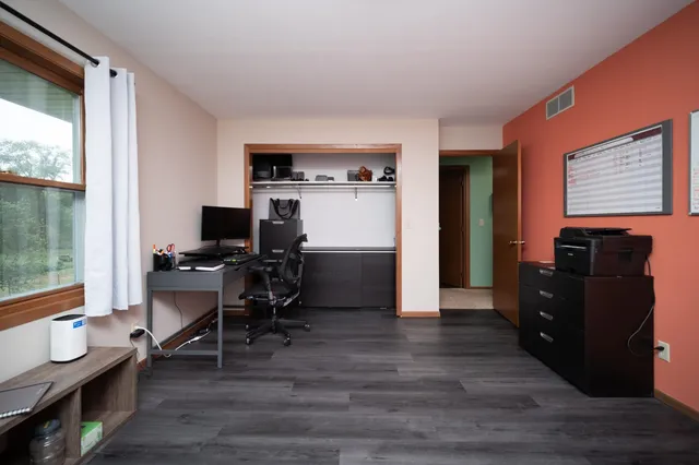 a view of a workspace with furniture and a window