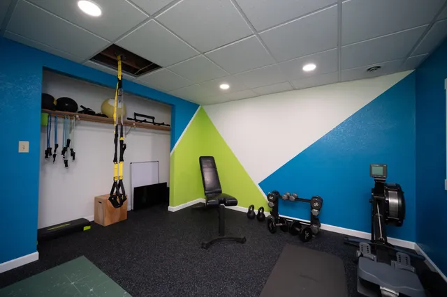 a room with gym equipment and windows