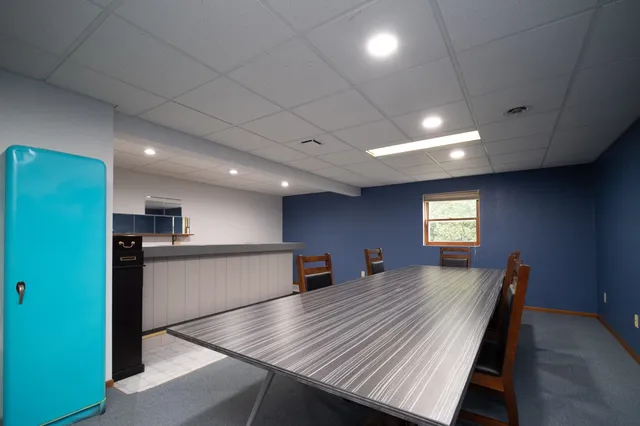 a kitchen with a refrigerator and a wooden floor