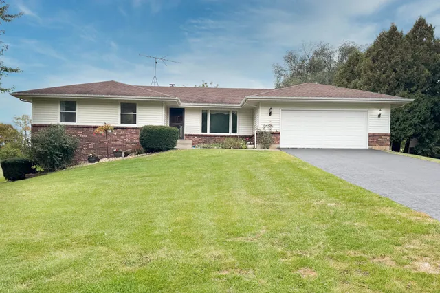 a front view of a house with yard and green space