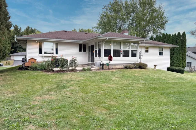 a front view of a house with a garden and trees