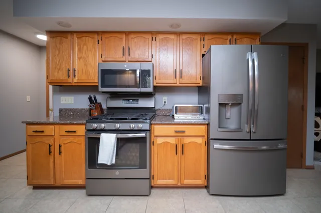 a kitchen with stainless steel appliances granite countertop a refrigerator stove a sink and a microwave