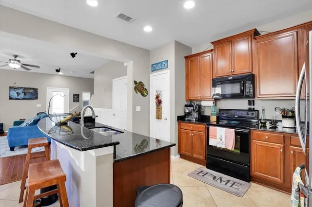 a kitchen with stainless steel appliances granite countertop a stove refrigerator and cabinets