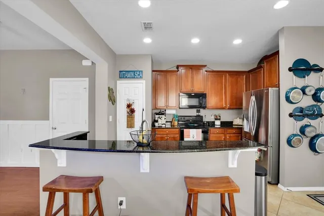 a kitchen with a refrigerator a stove a sink cabinets and a dining table