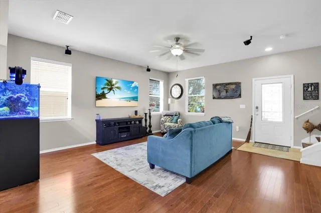 a living room with furniture and a wooden floor