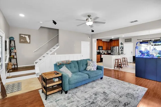 a living room with furniture and a wooden floor