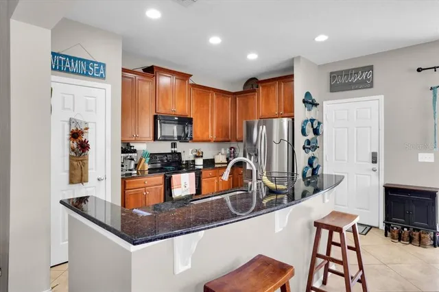 a kitchen with stainless steel appliances granite countertop a refrigerator a stove top oven a sink and dishwasher