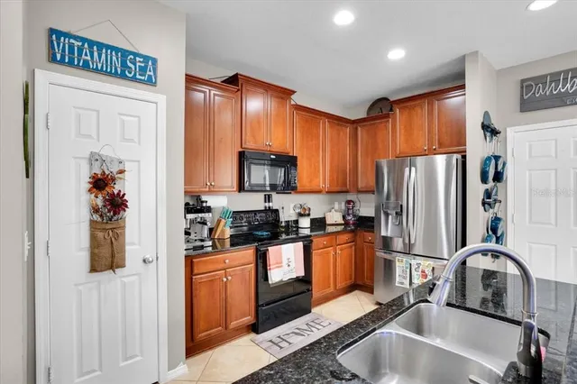 a kitchen with stainless steel appliances granite countertop a refrigerator sink and stove