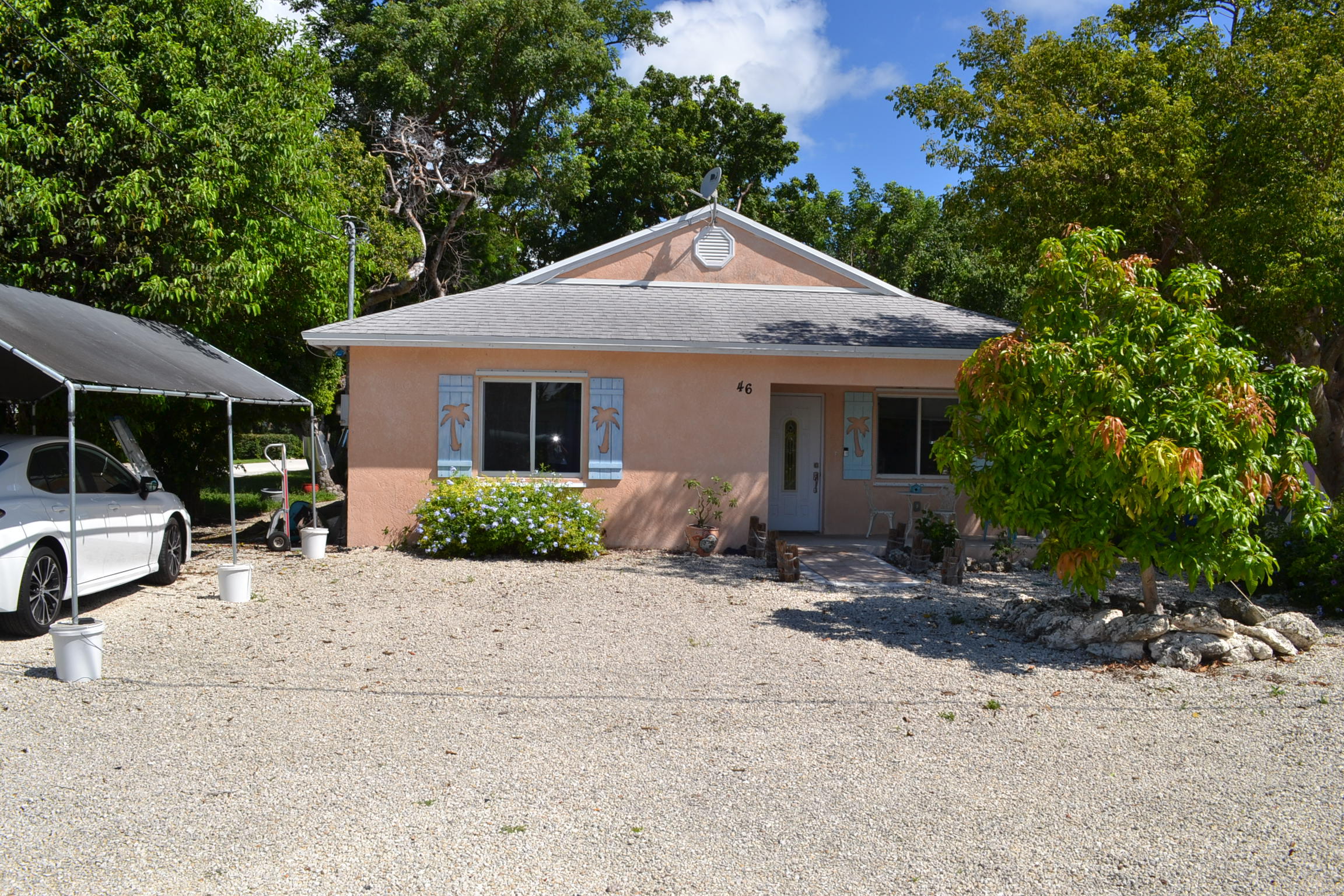 46 Snapper Avenue Key Largo, FL 33037 - Photo 1 of 26 a front view of a house with a yard and potted plants