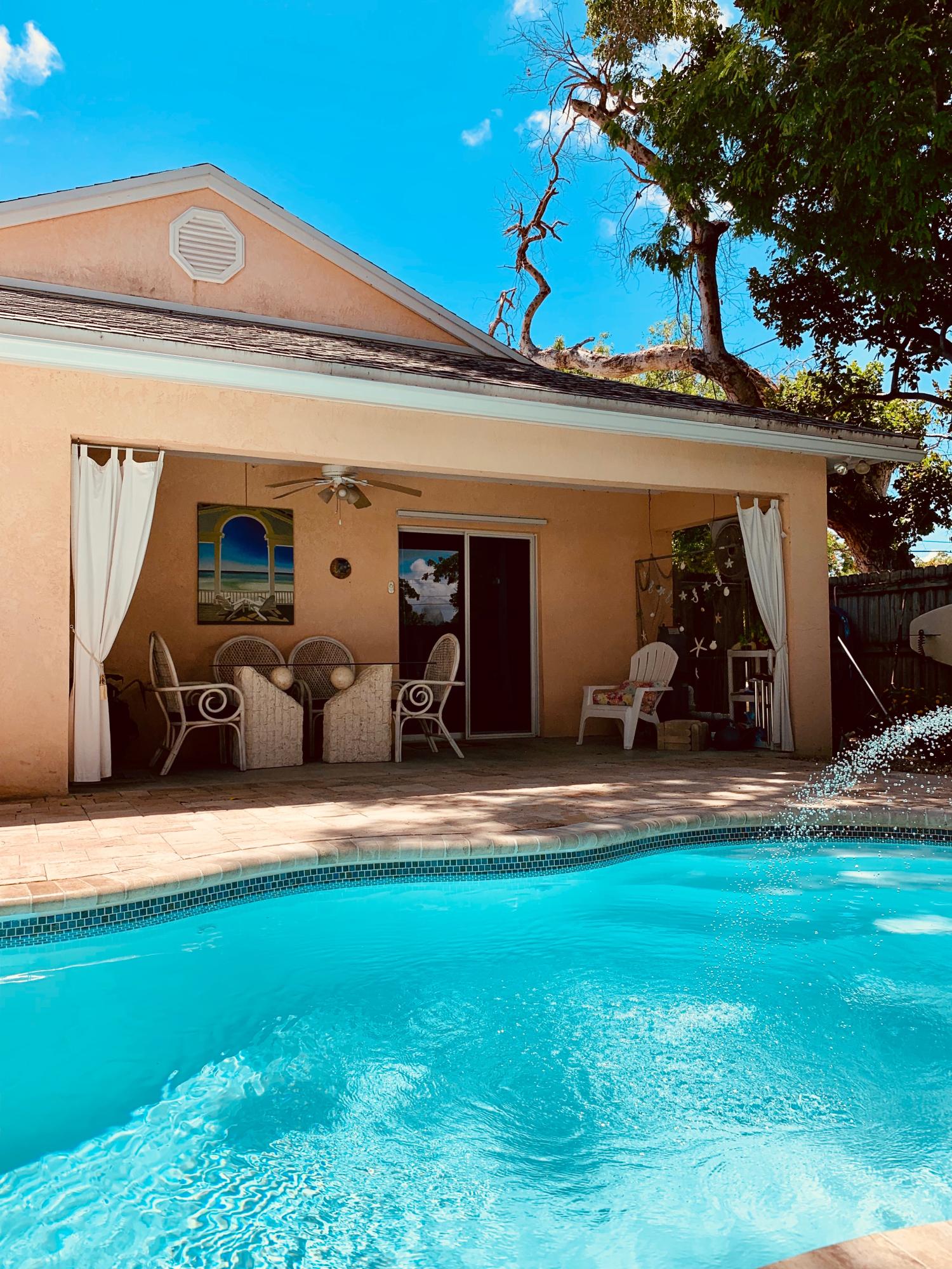 46 Snapper Avenue Key Largo, FL 33037 - Photo 19 of 26 a backyard of a house with table and chairs