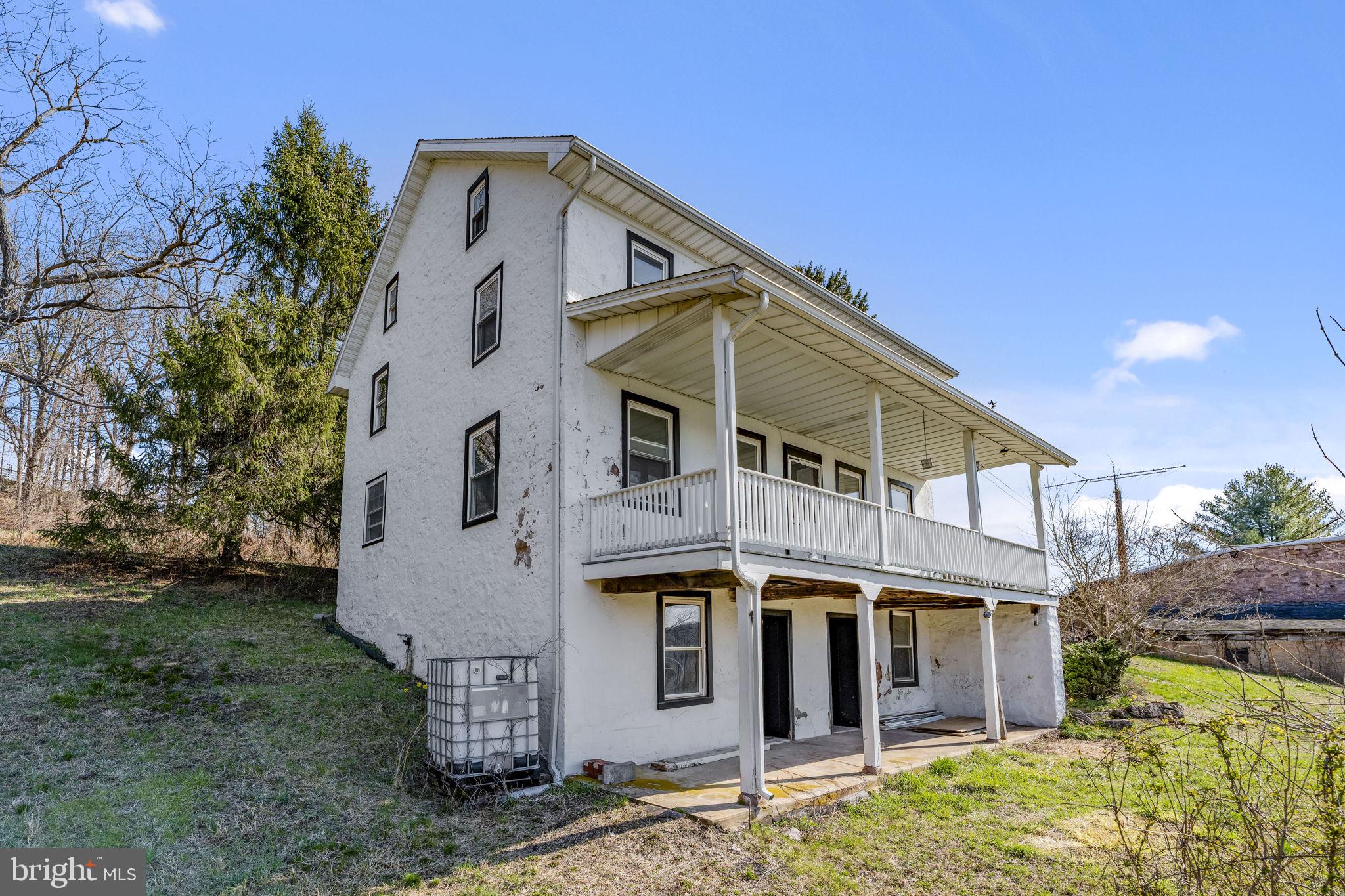 39 Gill Road Mohnton, PA 19540 - Photo 28 of 59 a view of a white house with large windows and a small yard