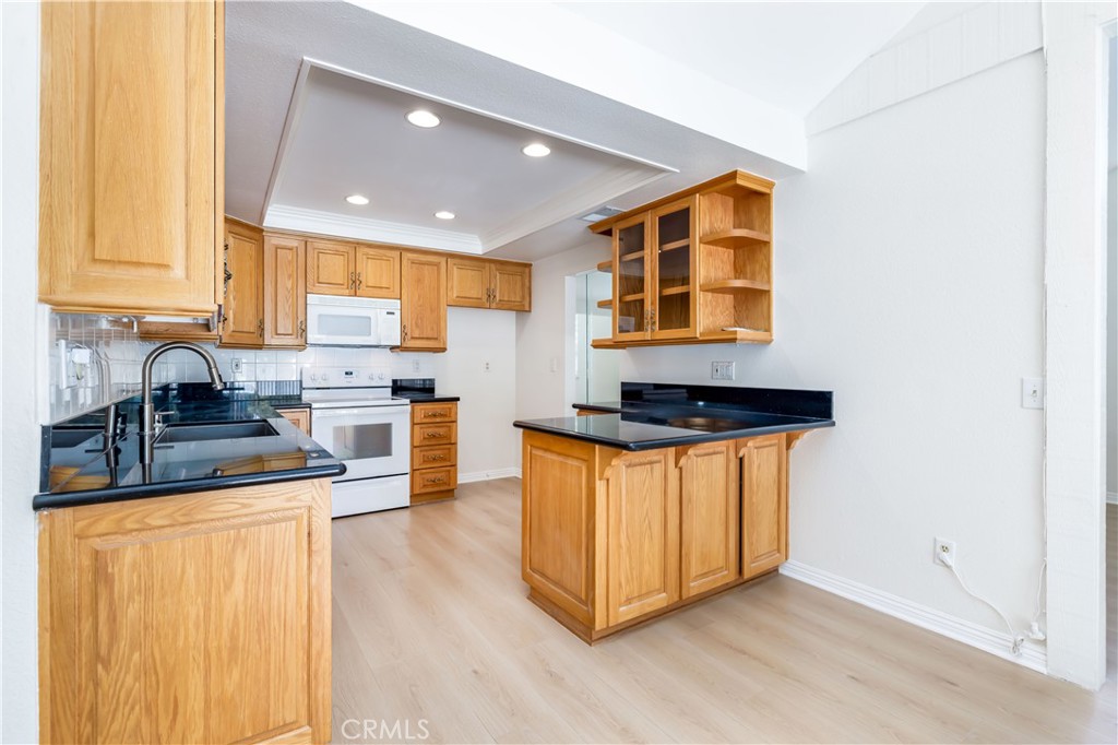 10215 Larwin Avenue, Unit 4 Chatsworth, CA 91311 - Photo 16 of 38 a kitchen with stainless steel appliances granite countertop a stove a sink and a microwave