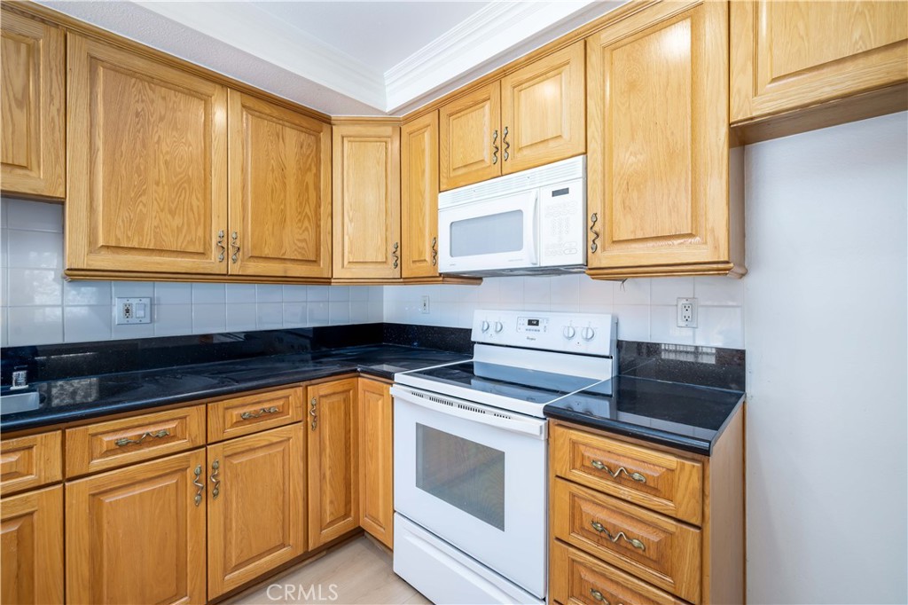 10215 Larwin Avenue, Unit 4 Chatsworth, CA 91311 - Photo 17 of 38 a kitchen with stainless steel appliances granite countertop white cabinets and a granite counter tops