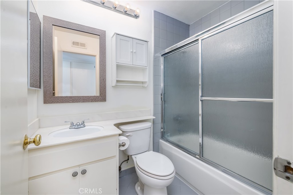 10215 Larwin Avenue, Unit 4 Chatsworth, CA 91311 - Photo 22 of 38 a bathroom with a shower a toilet a sink and mirror