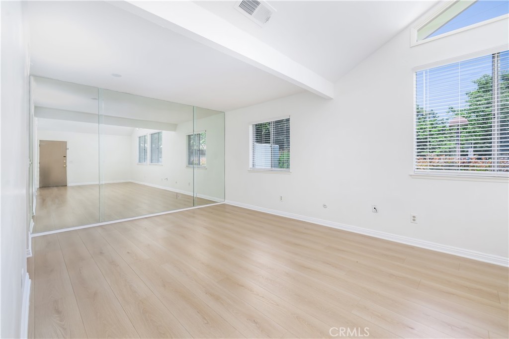 10215 Larwin Avenue, Unit 4 Chatsworth, CA 91311 - Photo 6 of 38 an empty room with wooden floor and windows
