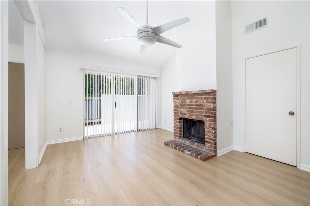 10215 Larwin Avenue, Unit 4 Chatsworth, CA 91311 - Photo 10 of 38 a view of an empty room with wooden floor fireplace and a window