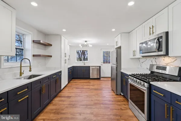 a large kitchen with stainless steel appliances a refrigerator and a sink