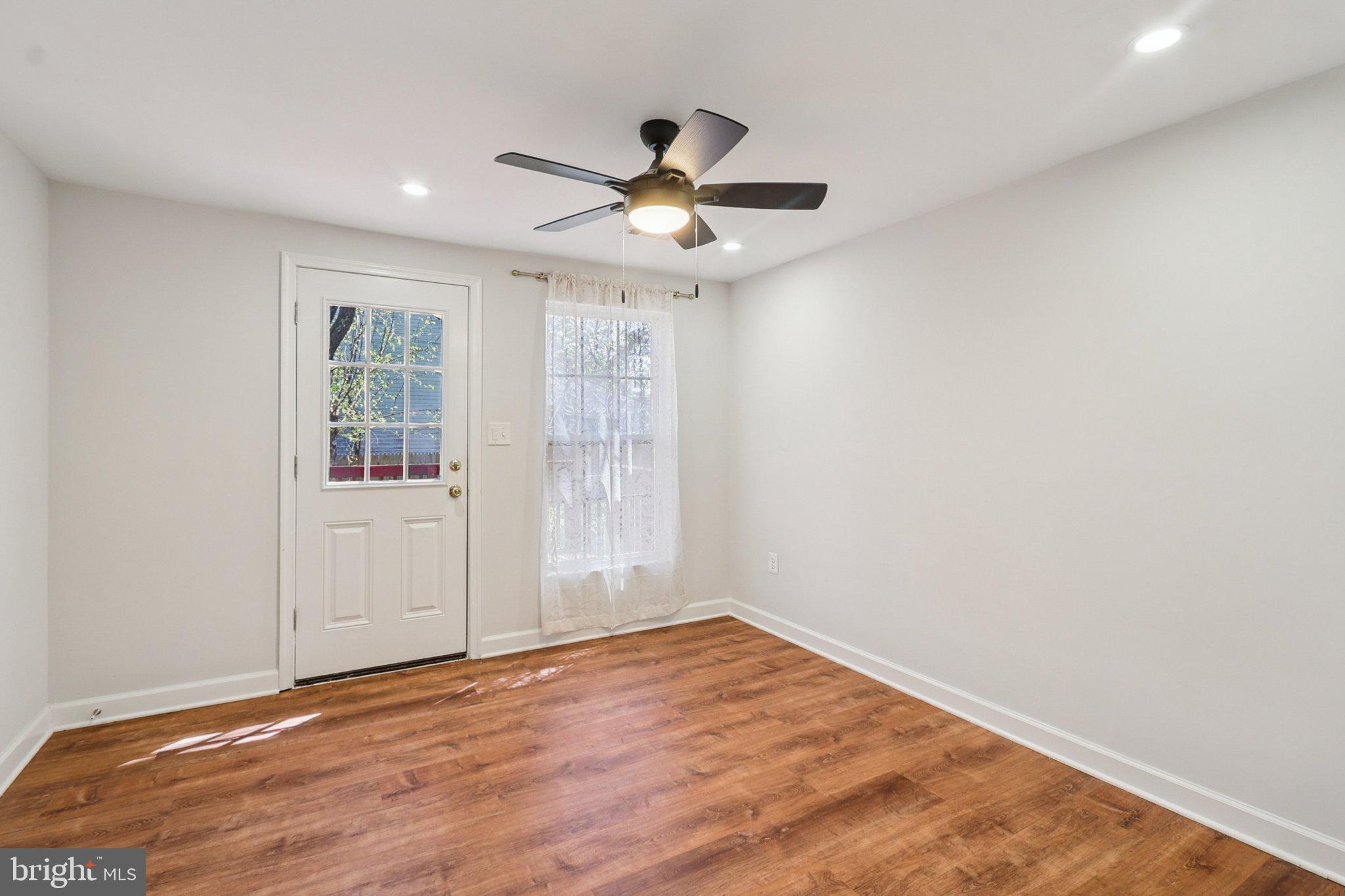 4357 Southern Avenue Southeast Capitol Heights, MD 20743 - Photo 32 of 84 an empty room with wooden floor chandelier fan and windows