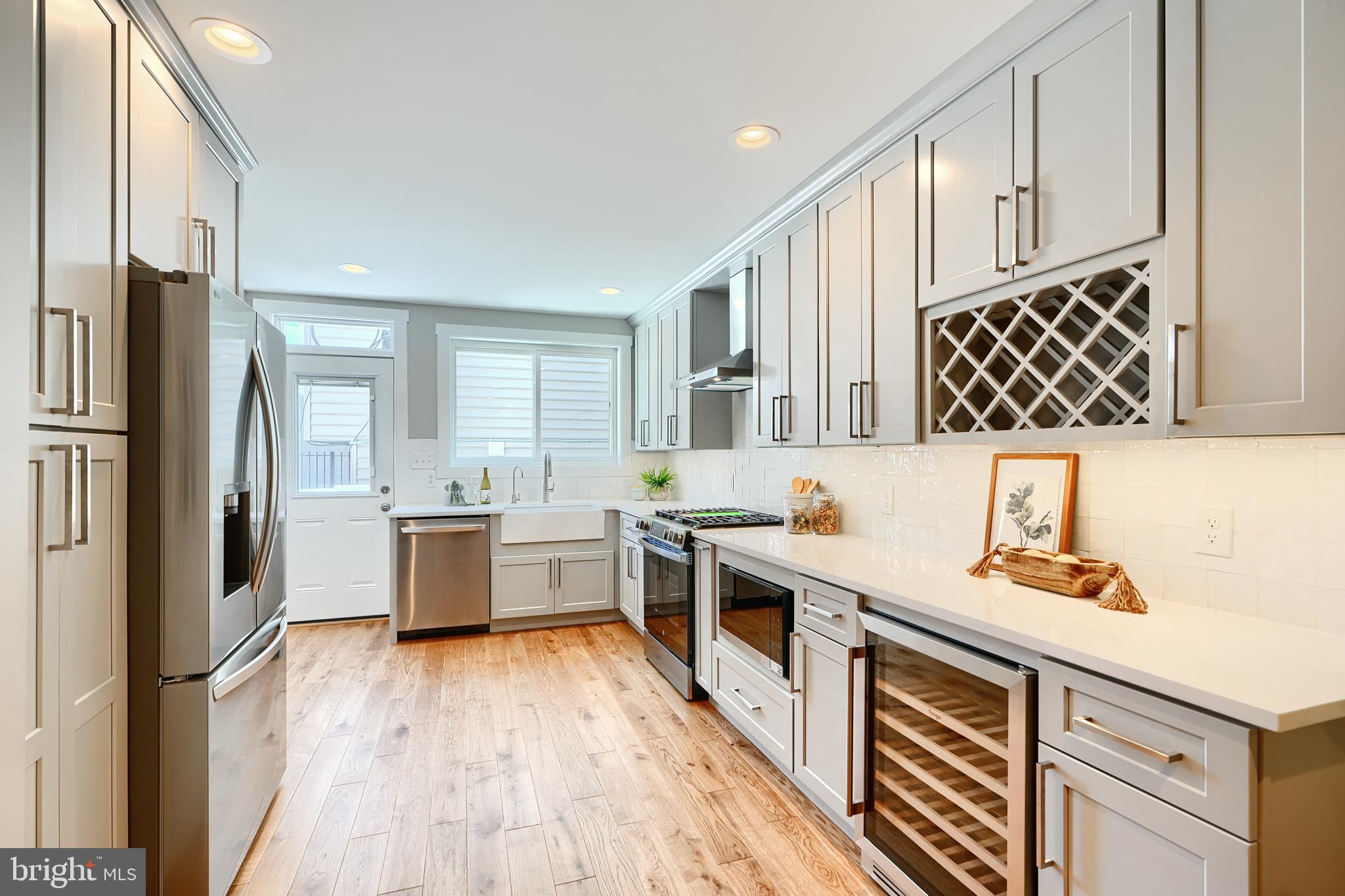 3029 Hudson Street Baltimore, MD 21224 - Photo 14 of 52 a kitchen with stainless steel appliances a refrigerator a sink and wooden floors