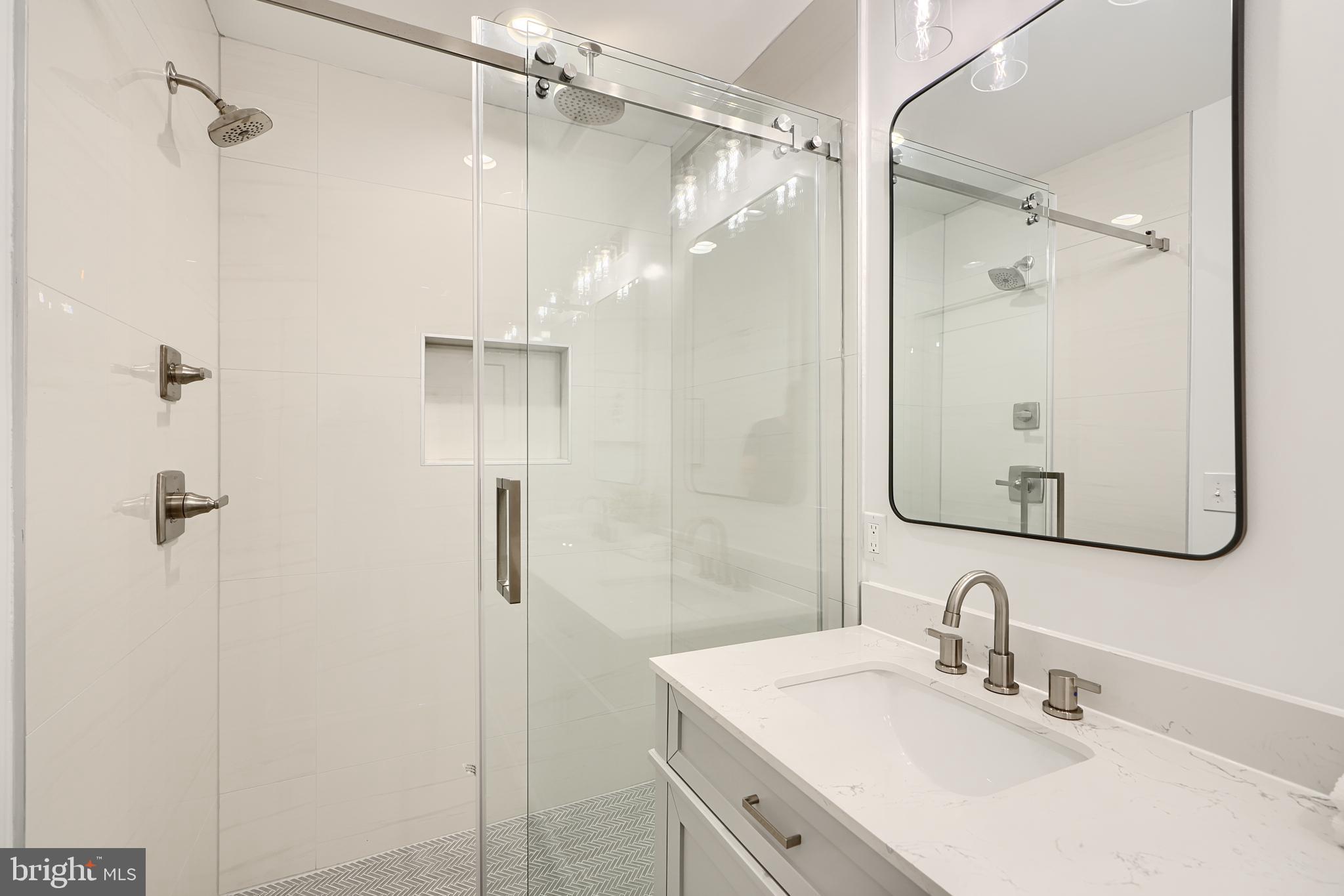 3029 Hudson Street Baltimore, MD 21224 - Photo 31 of 52 a bathroom with a shower sink vanity and a mirror