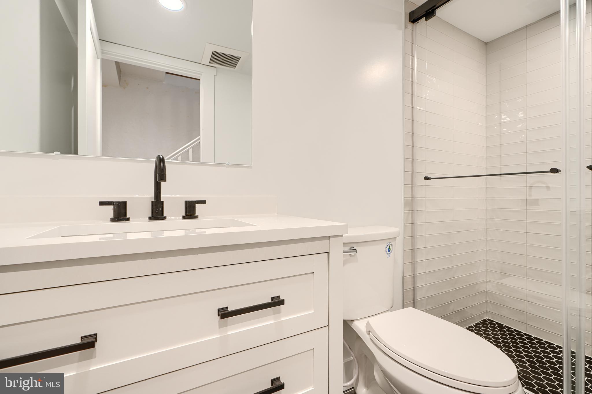 3029 Hudson Street Baltimore, MD 21224 - Photo 43 of 52 a bathroom with a sink a mirror a toilet and shower