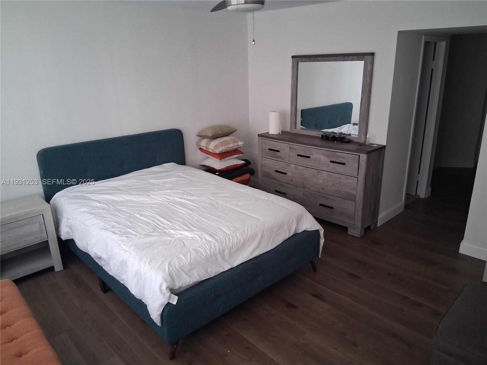 1750 Northeast 191st Street, Unit 1041 Miami, FL 33179 - Photo 12 of 17 a bedroom with a bed and a flat screen tv