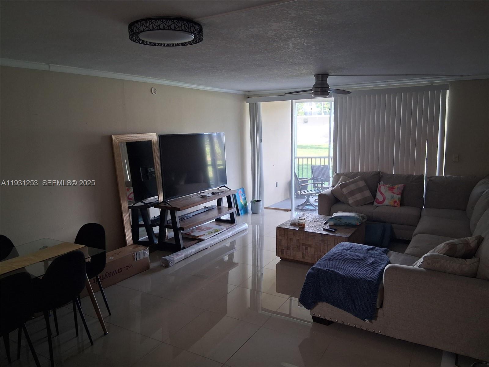 1750 Northeast 191st Street, Unit 1041 Miami, FL 33179 - Photo 14 of 17 a living room with furniture and a flat screen tv