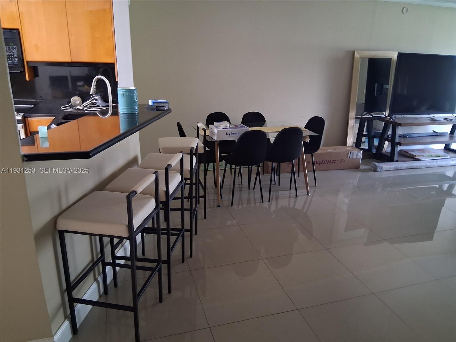 1750 Northeast 191st Street, Unit 1041 Miami, FL 33179 - Photo 15 of 17 a view of a dining room with furniture and chandelier