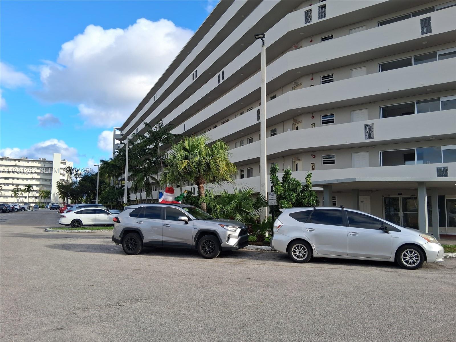 1750 Northeast 191st Street, Unit 1041 Miami, FL 33179 - Photo 2 of 17 a view of a cars parked in front of a building