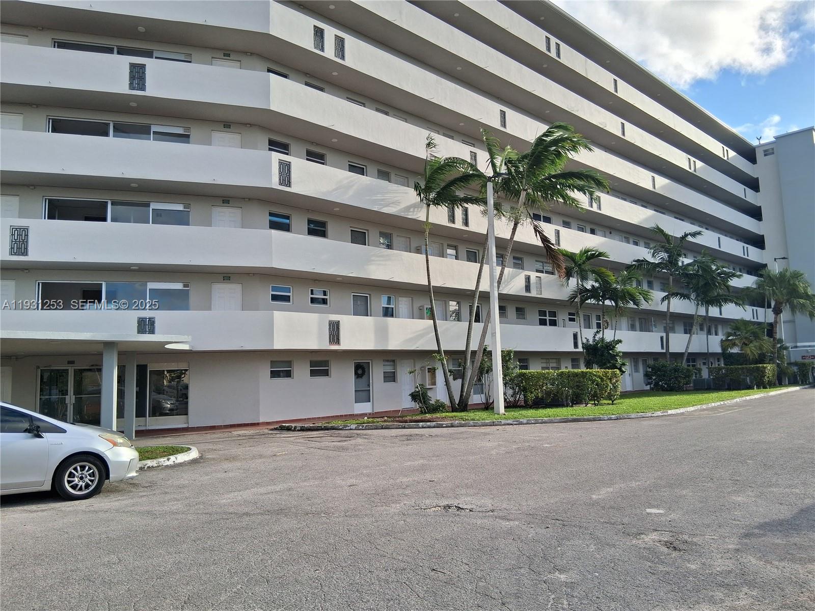 1750 Northeast 191st Street, Unit 1041 Miami, FL 33179 - Photo 3 of 17 a view of building with parking area