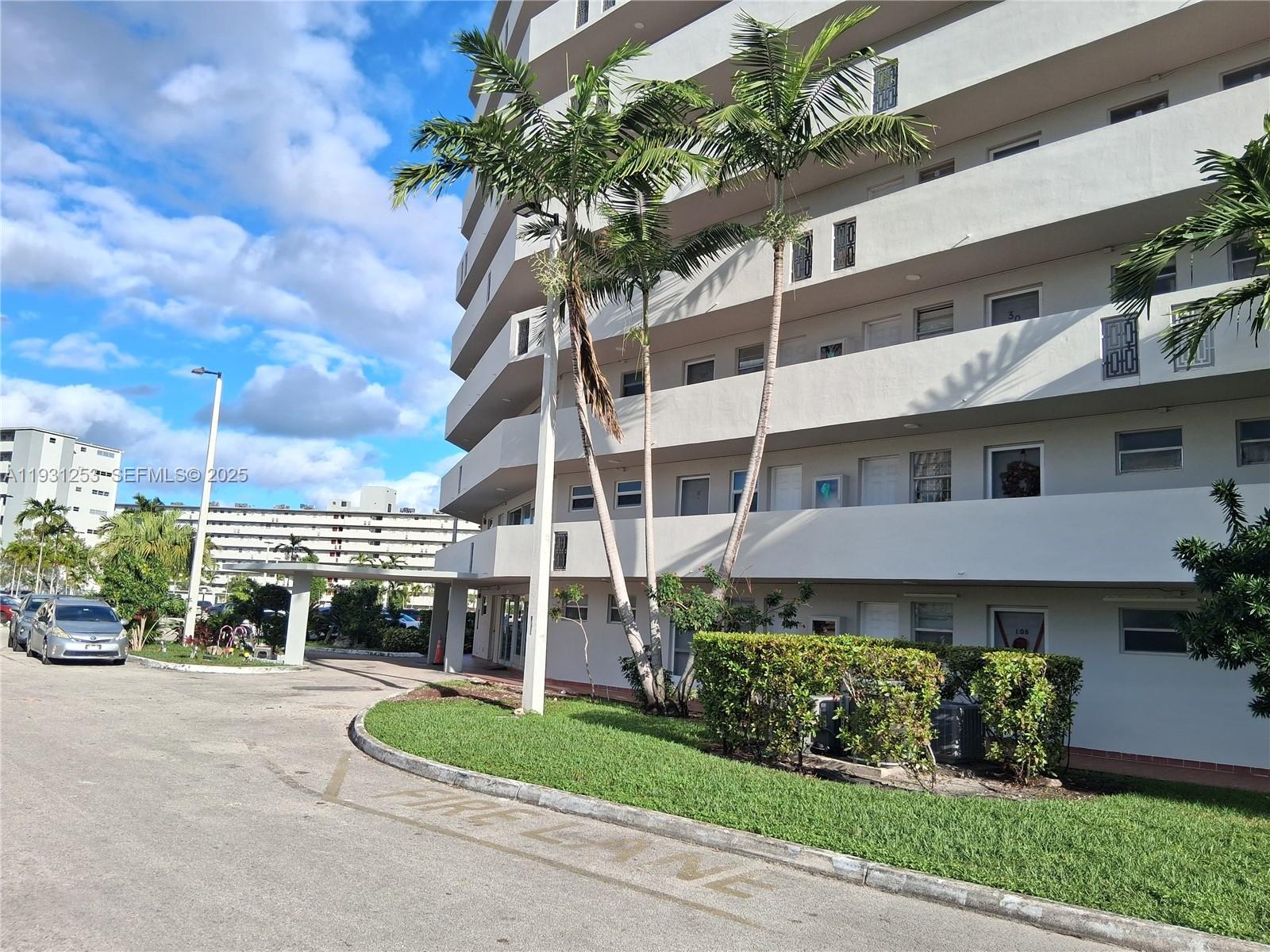 1750 Northeast 191st Street, Unit 1041 Miami, FL 33179 - Photo 5 of 17 a front view of a house with a yard and potted plants
