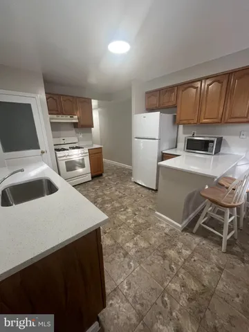 a kitchen that has a sink cabinets and wooden floor