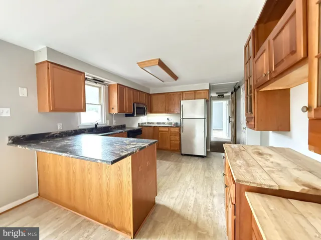 a kitchen with stainless steel appliances granite countertop a refrigerator and a stove top oven